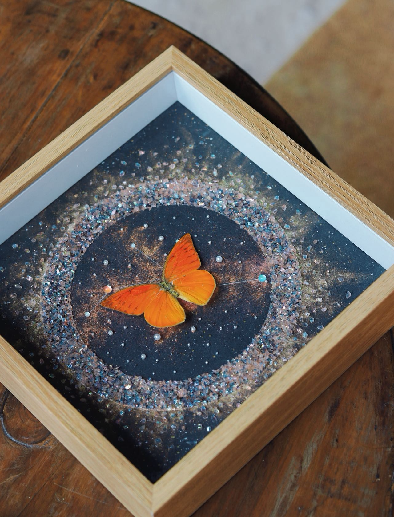 Orange butterfly artwork surrounded by a circular mineral composition
